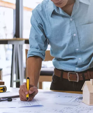 A contractor works on project blueprints